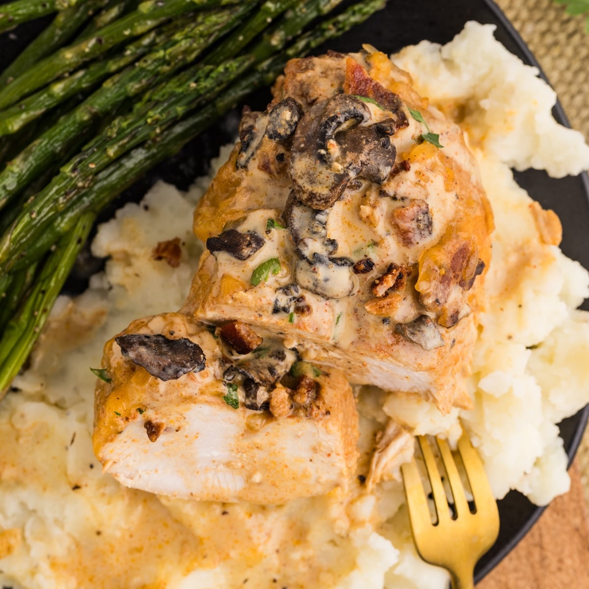 Plated Alice Springs Chicken with mashed potatoes and asparagus.