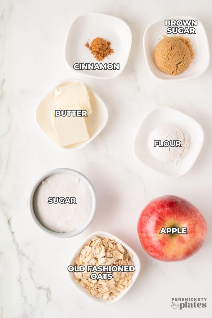 Labeled ingredients for apple crisp arranged on a white surface.