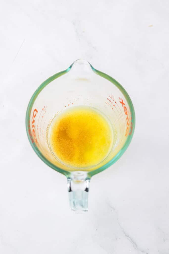 Melted butter in a glass measuring cup.