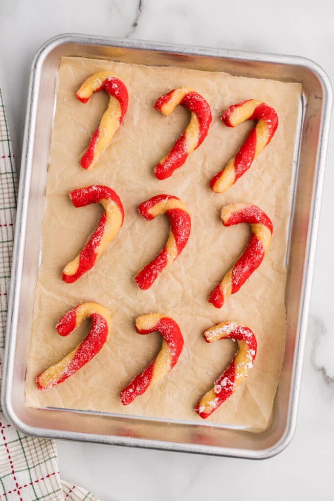 Candy cane cookies arranged on a baking pan.