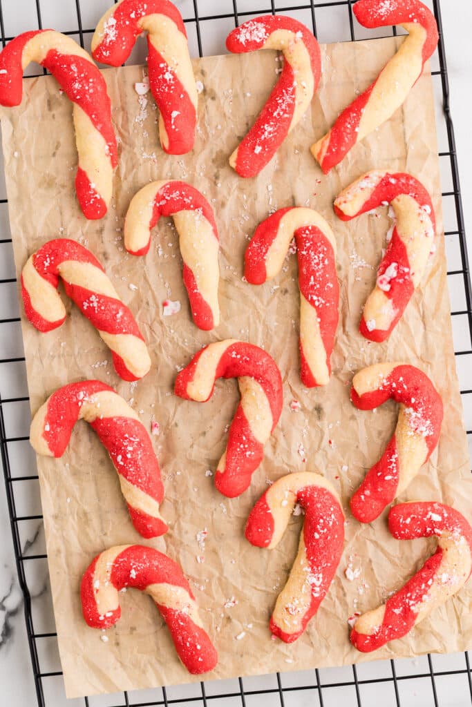 Baked candy cane cookies cooling on parchment paper.