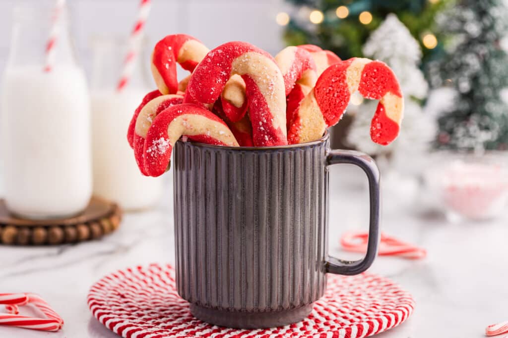 Candy cane cookies standing upright in a mug.