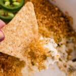 Tortilla chip dipped into jalapeño popper dip.